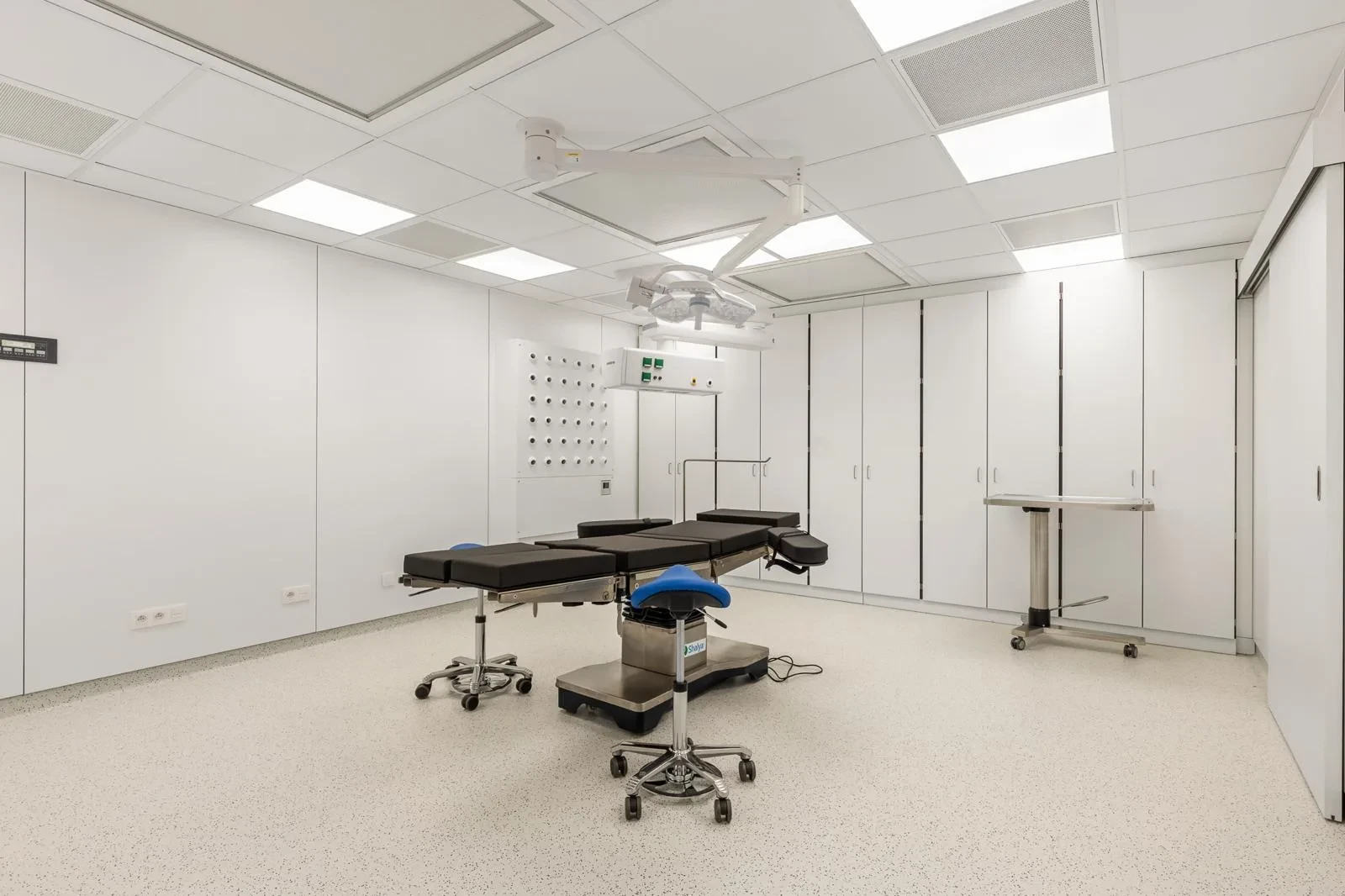 Overzicht van de operatiekamer met operatietafel en moderne uitrusting.