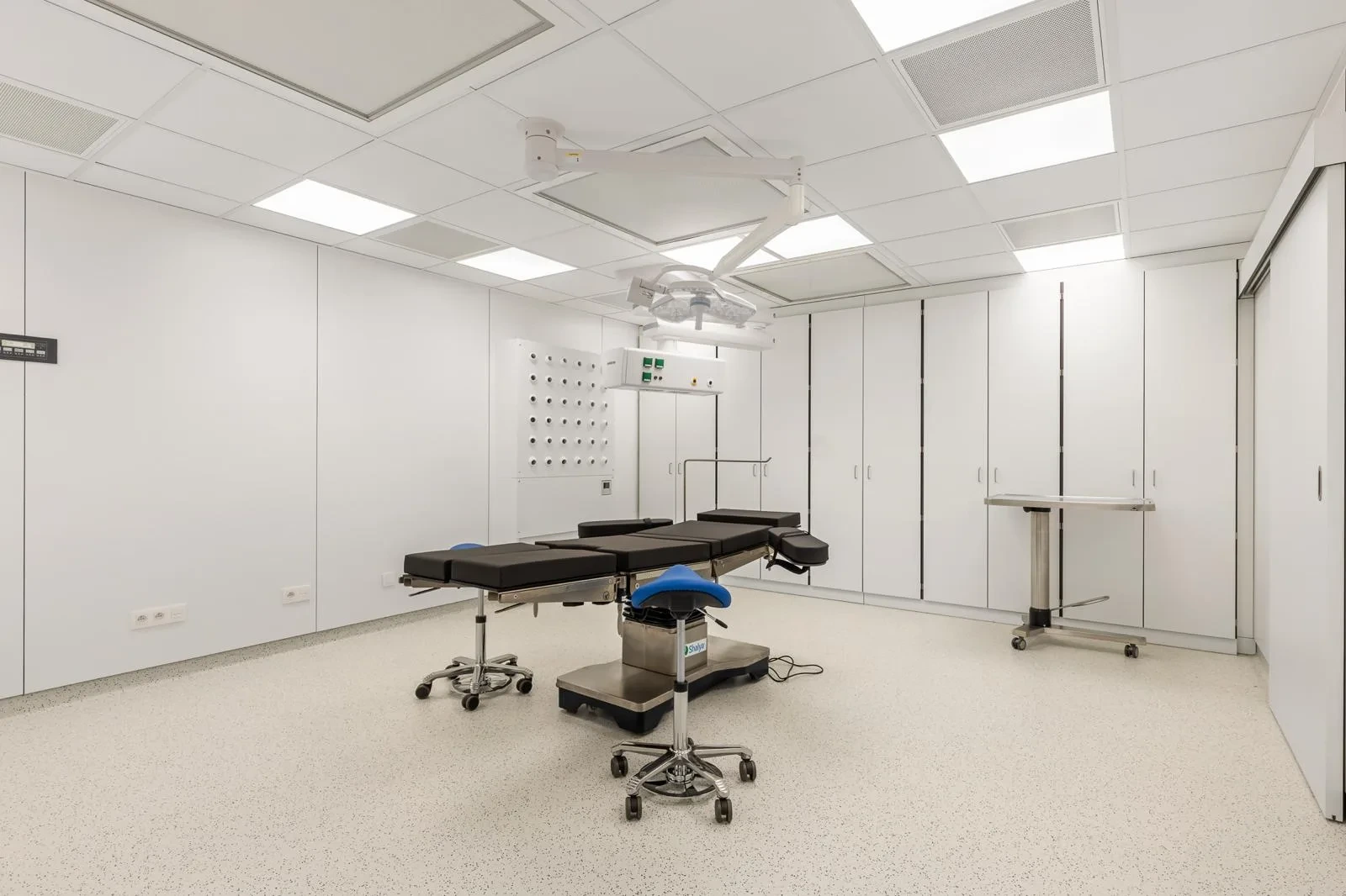 Overzicht van de operatiekamer met operatietafel en moderne uitrusting.