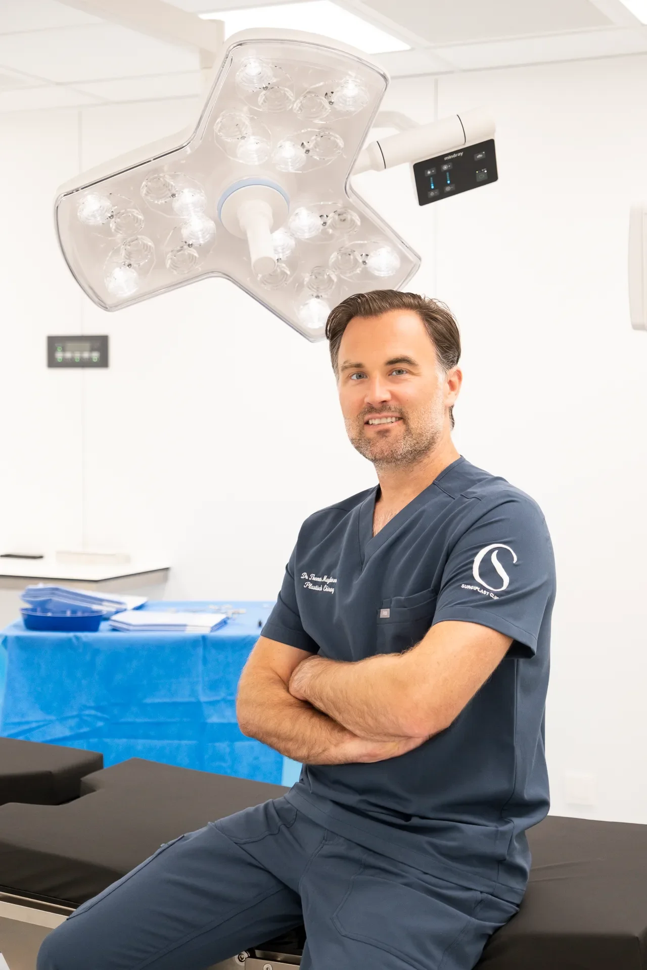 Dr. Muyldermans glimlacht in de operatiekamer onder de operatielamp.