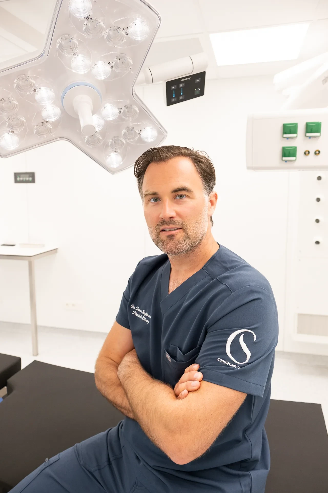 Portret van Dr. Muyldermans in de operatiekamer met gekruiste armen.