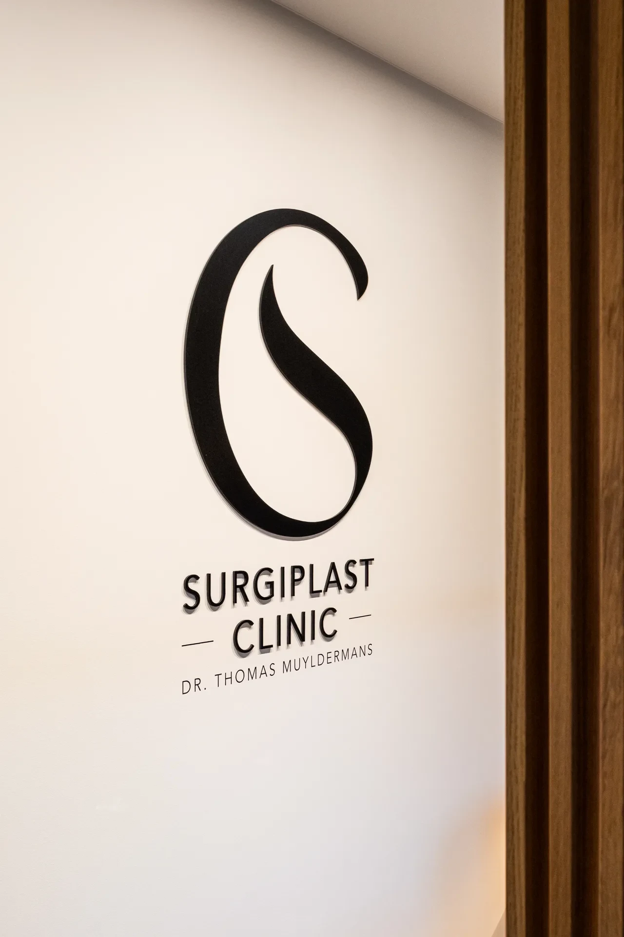 Detailopname van het wandlogo van Surgiplast Clinic.
